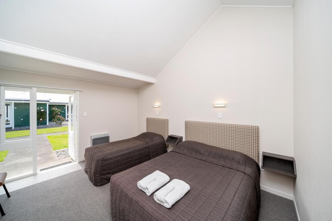 Bright studio room at The Furlong Motel with door open to the garden, Hawera